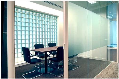 Meeting room behind frosted glazing beside a glass-block wall