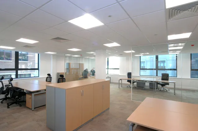 Open-plan office with timber desks, storage and glazed meeting rooms