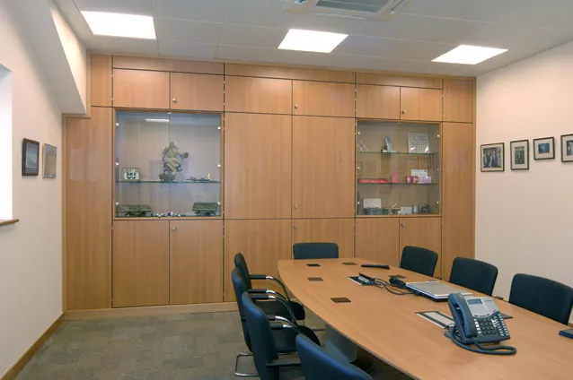 Boardroom with a long table, timber wall units and display cabinets