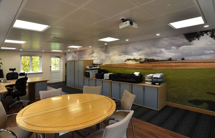 Meeting area with an oval table and a countryside wall mural