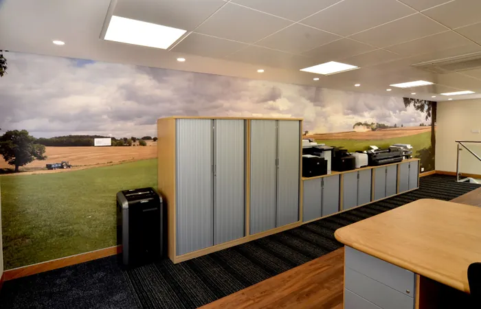Refurbished office with tambour storage units and a countryside wall mural